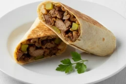 Vegan Sawda wrap with aubergine, potato, tomato, pepper, onion, tahini, and pickles.